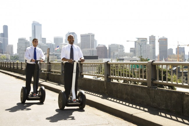 Two business men travelling on segways
